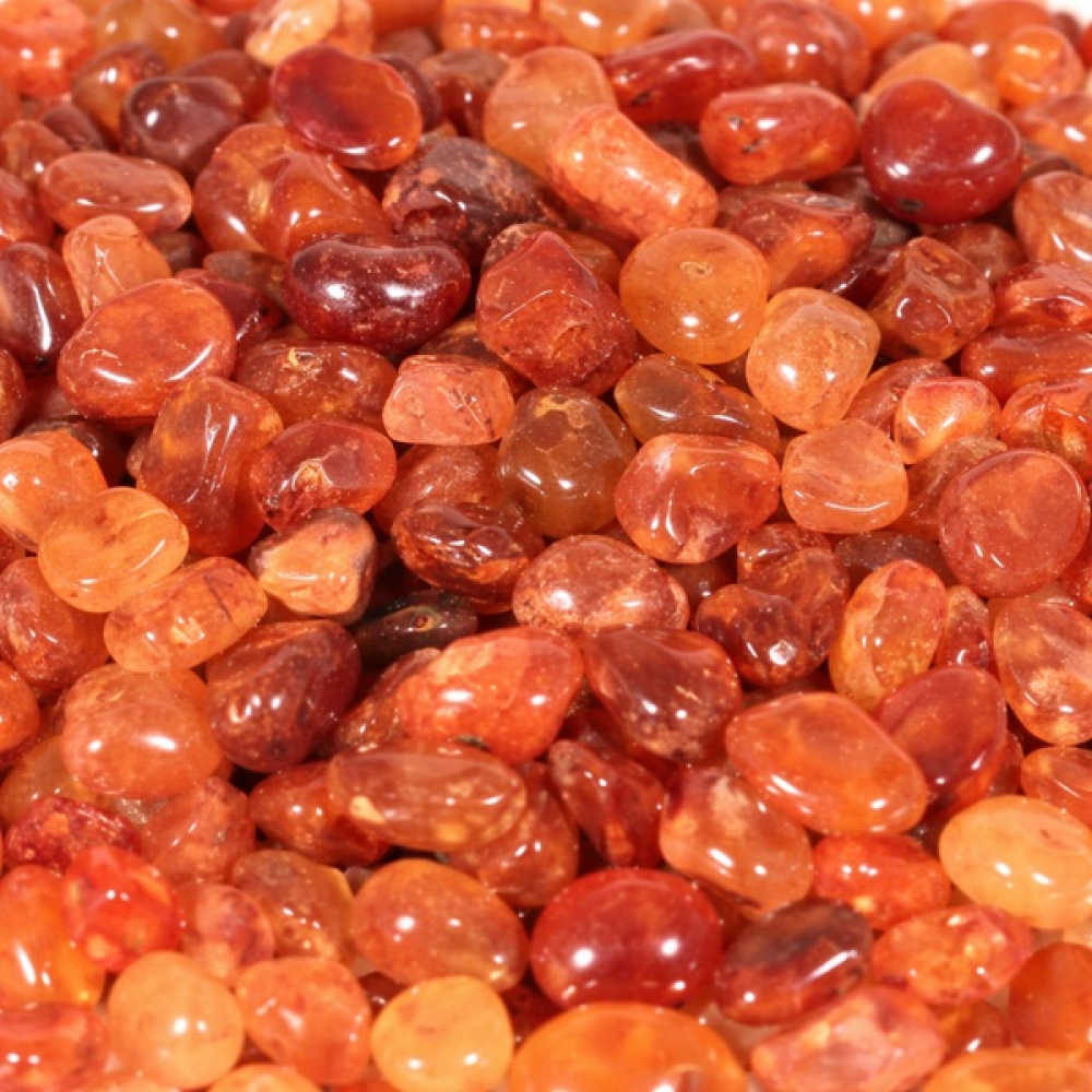 Karneol Mini Trommelsteine in Nahaufnahme mit vielen kleinen Steinen in warmen Orange- und Rottönen