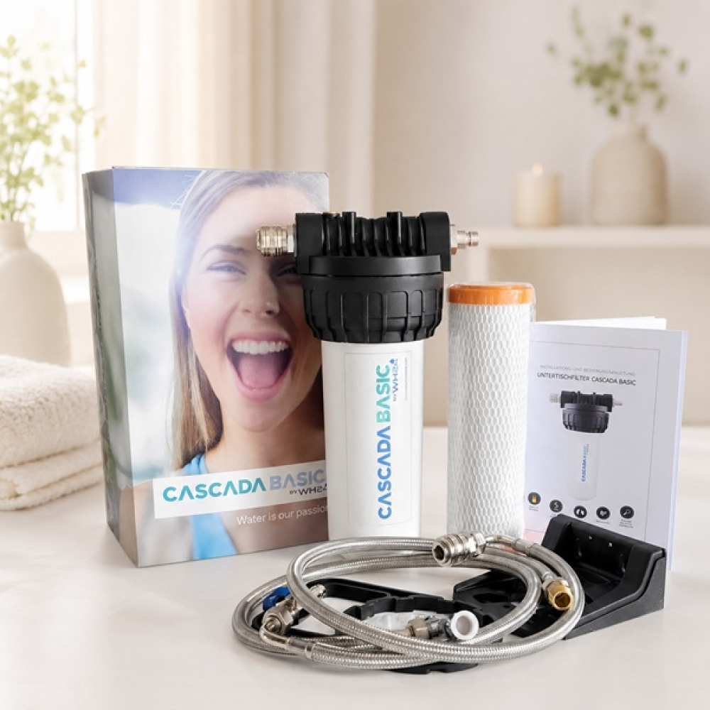 CASCADA BASIC water filter system with package contents including filter cartridge, connection hoses, mounting bracket and packaging in a soft bright setting